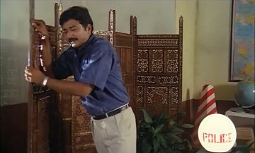 Jayaram being emotional leaning on to a wooden divider (ജയറാം റൂം ഡിവൈഡറിൽ ചാരുന്നു)